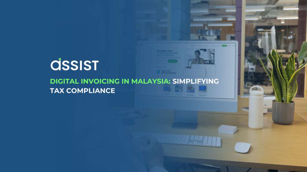 A professional workspace with a desktop screen displaying an e-invoicing platform, highlighting 'Digital Invoicing in Malaysia: Simplifying Tax Compliance' with the Assist logo.