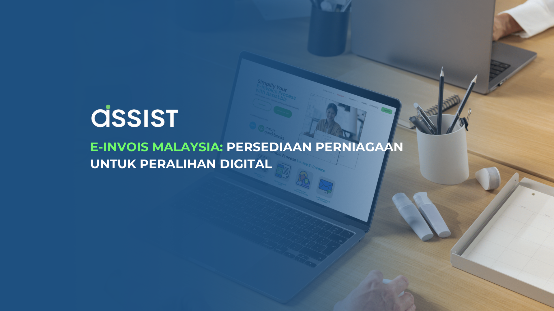 E-Invois Malaysia di meja kerja dengan komputer riba terbuka, alat tulis, dan kotak putih. Teks "assist" dan tajuk E-Invois Malaysia: Persediaan Perniagaan untuk Peralihan Digital dipaparkan di atas latar belakang biru.